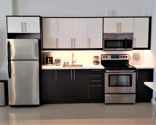 a kitchen with white cabinets and stainless steel appliances at KASA The Lofts of Old San Juan 202 HUGE 2 Bed 2 bath for 6 Interior Terrace in San Juan