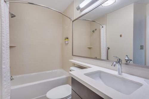 a bathroom with a sink and a toilet and a mirror at Candlewood Suites Secaucus, an IHG Hotel in Secaucus