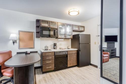 a kitchen with a table and a refrigerator at Candlewood Suites Secaucus by IHG in Secaucus