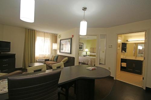 a living room with a dining room table in a hotel room at Candlewood Suites Newport News-Yorktown by IHG in Newport News