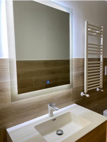 a bathroom with a sink and a large mirror at Hotel La Maison Delle Terme in Tivoli Terme