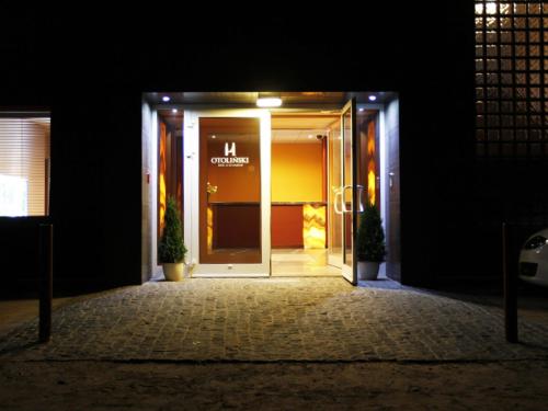 an open door to a building at night at Hotel Otoliński in Płock