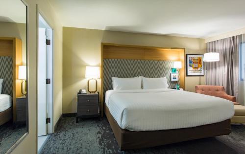 a hotel room with a large bed and a chair at Holiday Inn Chicago North Shore by IHG in Skokie