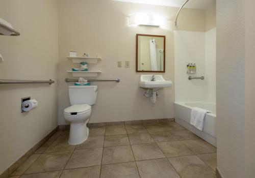 a bathroom with a toilet and a sink and a tub at Candlewood Suites Mobile-Downtown, an IHG Hotel in Mobile