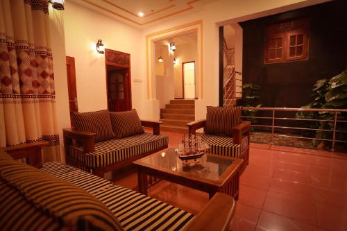 a living room with two couches and a coffee table at Nimnada Villa in Galle