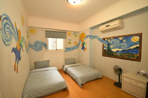 東港的住宿－東港麗園民宿，一间卧室设有两张床,墙上挂着一幅画