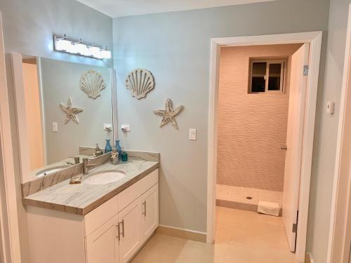 un bagno con lavandino e specchio di MODERN SPACIOUS BEACH FRONT CENTRAL CONDO w POOLS STEPS TO BEACH a Rosarito