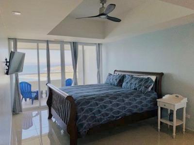 a bedroom with a bed and a ceiling fan at BEACHFRONT CONDO w POOLS STEPS TO BEACH & MINS TO DT in Rosarito