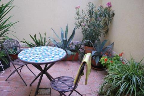 une terrasse avec une table, des chaises et des plantes dans l'établissement Chez Alfred et Régine, à Rouffach