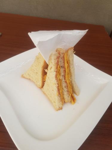 a sandwich on a white plate on a table at Obelisk Hotel Axum in Āksum