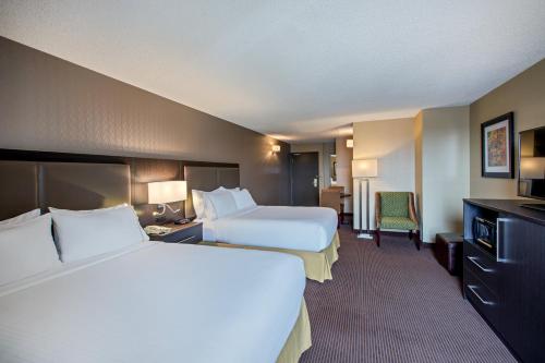 a hotel room with two beds and a television at Quality Inn & Suites Regina Downtown in Regina