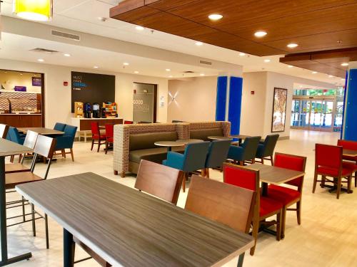 a dining room with tables and chairs and a cafeteria at Holiday Inn Express & Suites Raleigh Airport - Brier Creek by IHG in Raleigh