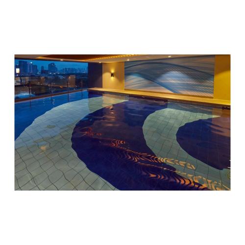 a swimming pool with a painting on the side of a building at Summit Hotel Greenhills in Manila