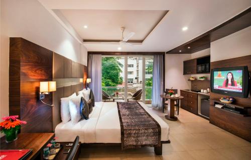 a hotel room with a bed and a television at Lords Eco Inn Bengaluru Jayanagar in Bangalore