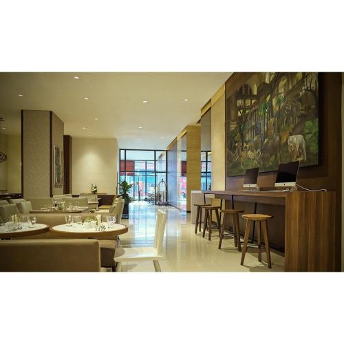 a restaurant with tables and chairs and a painting on the wall at Summit Hotel Greenhills in Manila