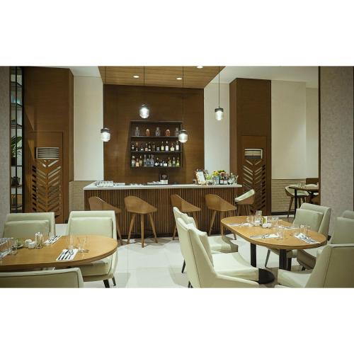 a restaurant with tables and chairs and a bar at Summit Hotel Greenhills in Manila