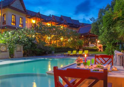 Phuwanalee Resort في مو سي: طاولة طعام أمام منزل مع مسبح