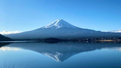 a mountain reflection in a lake with a mountain in the background at Lake Villa Kawaguchiko in Fujikawaguchiko