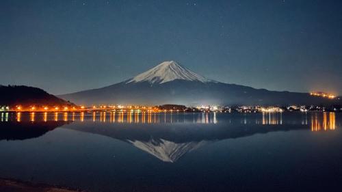 a mountain with a reflection in the water at night at Lake Villa Kawaguchiko in Fujikawaguchiko