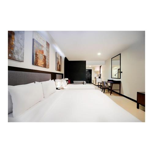 a large white bed in a hotel room at Summit Hotel Magnolia in Manila