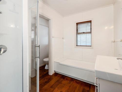 a white bathroom with a tub and a sink at Taupo Panorama - Lake Taupo Holiday Home in Taupo