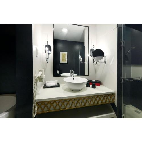 a bathroom with a sink and a mirror at Summit Hotel Magnolia in Manila