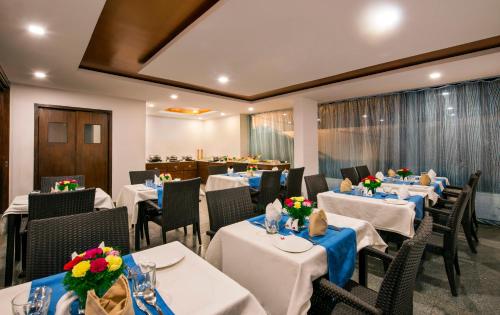 a restaurant with tables and chairs with blue table cloth at Lords Eco Inn Bengaluru Jayanagar in Bangalore