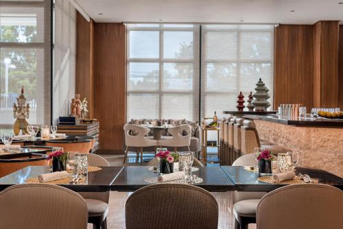 a dining room with tables and chairs and windows at Dusit Thani Residence Davao in Davao City
