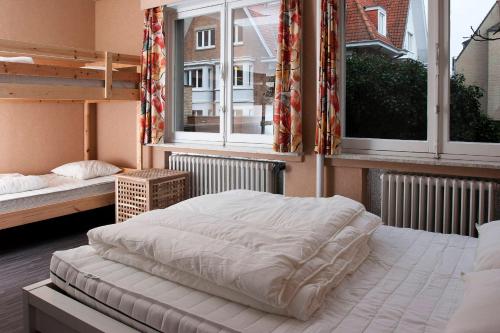 1 dormitorio con 2 literas y 2 ventanas en Apartment Valdemosa, en De Haan