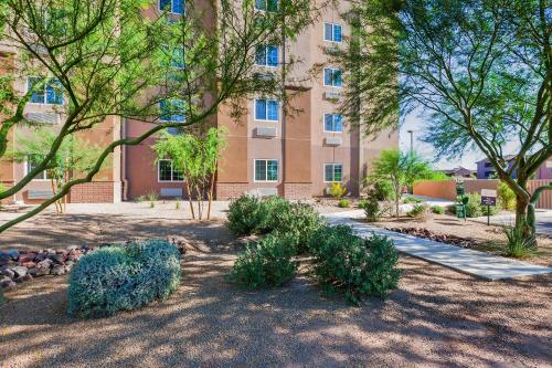 a building with trees and plants in front of it at Candlewood Suites Tucson by IHG in Tucson