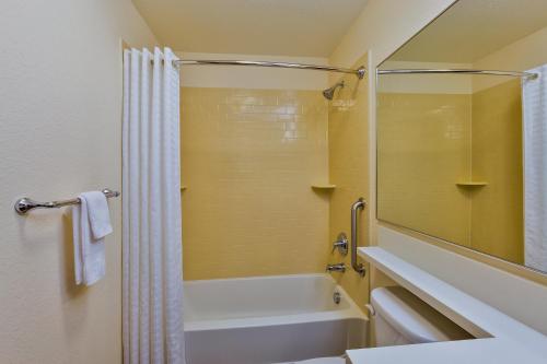 y baño con bañera, ducha y lavamanos. en Candlewood Suites Tucson, an IHG Hotel en Tucson