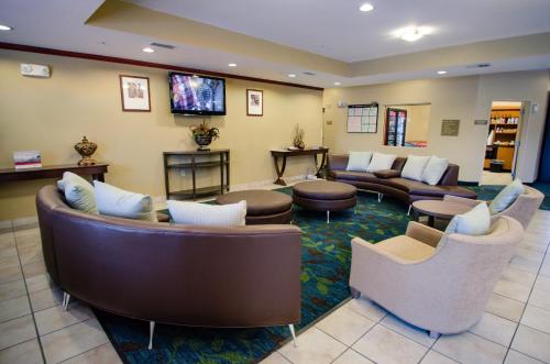 a waiting room with couches and chairs and a tv at Candlewood Suites Temple by IHG in Temple