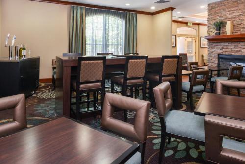 a restaurant with tables and chairs and a fireplace at Staybridge Suites Denver Tech Center by IHG in Centennial