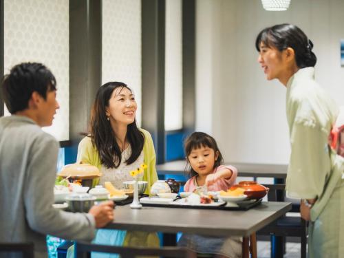 a group of people sitting around a table eating food at Hotel Nikko Huis Ten Bosch in Sasebo