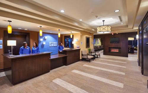 a lobby with two women at a reception desk at Holiday Inn Express & Suites Timmins by IHG in Timmins