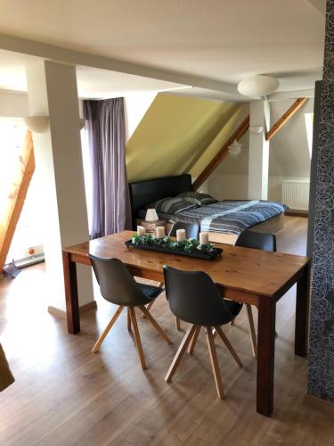 una sala da pranzo con tavolo e letto di Maisonette Wohnung mit Blick über die Stadt a Jena