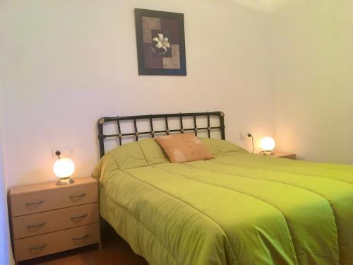 a bedroom with a green bed and two lamps at La Granada in Órgiva