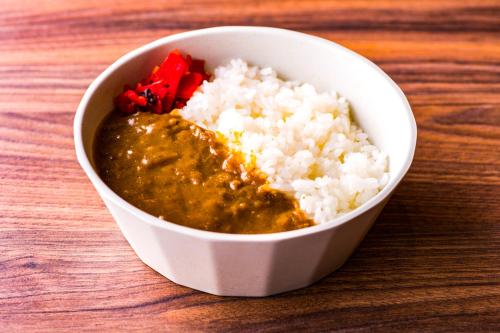 a white bowl of food with rice and sauce at The Celecton Matsumoto in Matsumoto