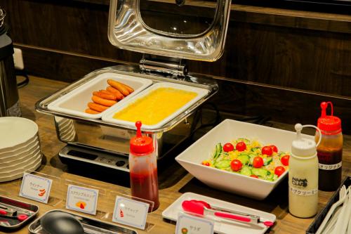 a table with a tray of food and a bowl of vegetables at The Celecton Matsumoto in Matsumoto