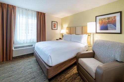 una camera d'albergo con letto e divano di Candlewood Suites Washington-Dulles Herndon, an IHG Hotel a Herndon