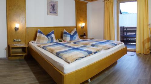 a bedroom with a large bed with blue and yellow pillows at Ferienwohnung Hartmann in Obermaiselstein
