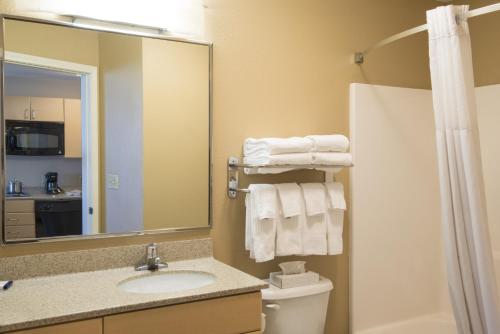 a bathroom with a sink and a toilet and a mirror at Candlewood Suites Sheridan by IHG in Sheridan
