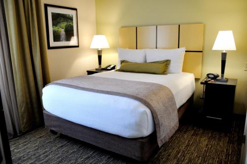 a large bed in a hotel room with two lamps at Candlewood Suites Sterling by IHG in Sterling