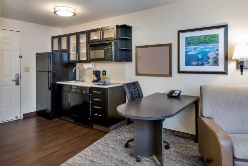 a kitchen with a desk and a table in a room at Candlewood Suites Sterling by IHG in Sterling