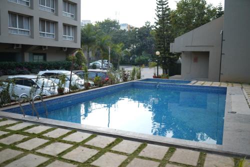 a large blue swimming pool next to a building at Inventree hotels & Resort in Pune