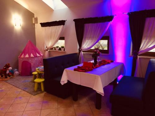 a living room with a table and a play tent at Motel-Restauracja Ballaton in Chustki