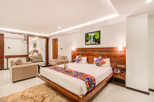 a bedroom with a bed and a desk and chairs at FabHotel The Royal Suites in Bangalore