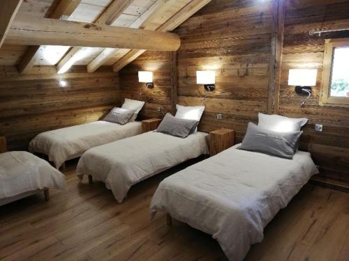um quarto com três camas num chalé de madeira em Chambres et Tables d'Hôtes Le Choton à Nono - Col du Joly Beaufortain em Hauteluce
