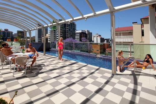 people are lounging in a swimming pool at Astor Metropole Hotel in Brisbane