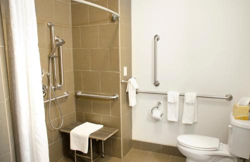 a bathroom with a toilet and a shower with towels at Candlewood Suites York, an IHG Hotel in York